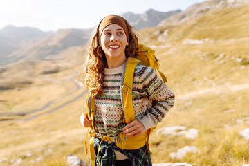 Young woman with hiking backpack enjoying hiking in mountains. Hiker enjoying mountain landscape...