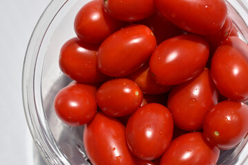 close up cherry tomatoes in transparent bowl top view 