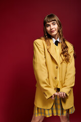 Young female student radiates confidence in bold yellow attire against a vivid backdrop