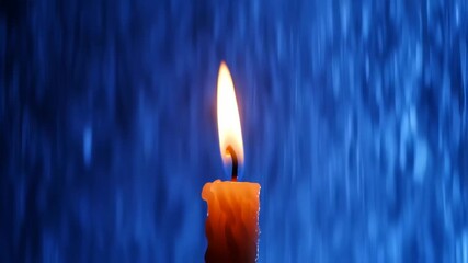 Single candle flame against a blurry blue background - Powered by Adobe