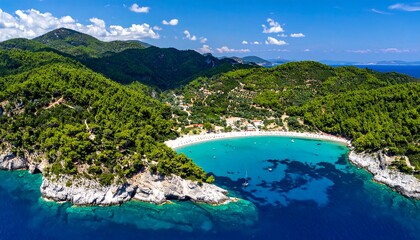 Obraz premium Picturesque coastal bay nestled within lush green mountains, showcasing a vibrant turquoise water body.