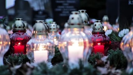 Rows of candle lanterns glowing solemnly on graves with a respectful and peaceful mood for All Saints’ Day with copy space