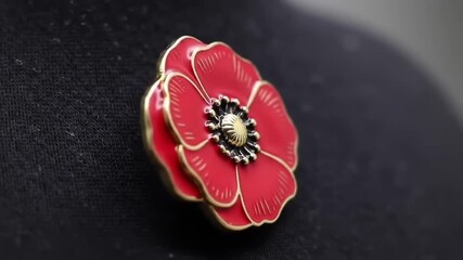 Close-up of a red poppy pin on black fabric with a solemn and respectful mood as a Remembrance Day symbol with copy space