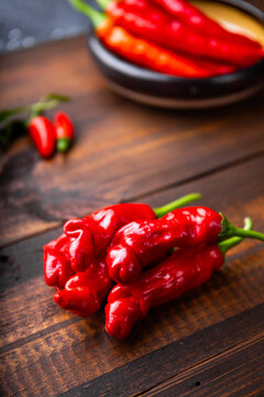 Ripe chili peppers in the shape of a penis, peter pepper on wooden background vertical photo