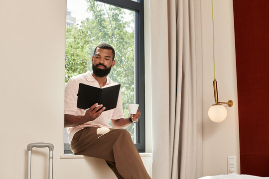 Stylish African American man relaxing in a modern hotel room while enjoying a coffee