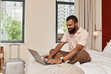 Stylish African American man relaxed in a modern hotel room on vacation