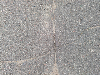 Close up of cracked asphalt pavement surface with rough texture