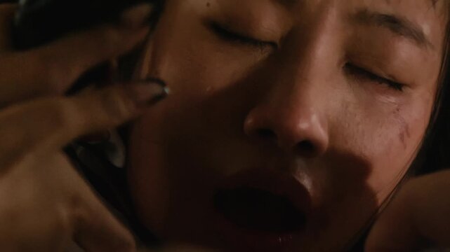 close up of young asiatic girl woman crying in fear while being physically abused and raped tortured chocked with a rope 4k video