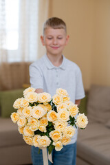 Teenage boy holding beautiful yellow rose bouquet ready to give mother for Mother's Day