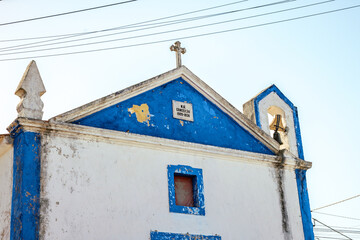 Artistic close-up of an old church in Óbidos, Portugal, showing stone details, religious symbols and the charm of traditional Portuguese architecture.