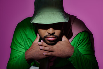 Stylish young Black man in trendy fashion against a vibrant backdrop