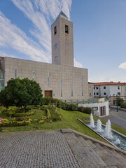 Mirandela's main Parish Church in Portugal stands atop the city’s highest hill, blending modern lines and historical elements. Photographed August 2025, with urban surroundings, no people.
