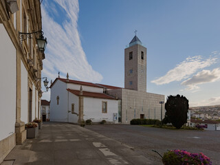 Mirandela's main Parish Church in Portugal stands atop the city’s highest hill, blending modern lines and historical elements. Photographed August 2025, with urban surroundings, no people.