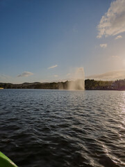Water jet fountain rises above the Tua River in Mirandela, Portugal, at dusk