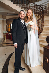 Naklejka premium The bride and groom are on a beautiful staircase.