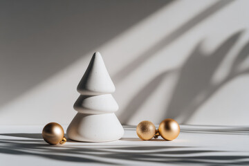 minimalist christmas tree elegantly adorned with golden ornaments stands out against clean white background