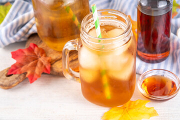 Sweet refreshing Maple Iced Tea Drink, tasty aromatic cold beverage with ice cubes and a lot of maple syrup, copy space