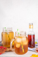 Sweet refreshing Maple Iced Tea Drink, tasty aromatic cold beverage with ice cubes and a lot of maple syrup, copy space