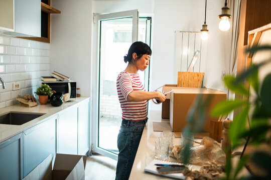 Woman packing boxes in kitchen