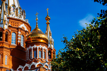 A majestic temple with golden domes, red brickwork and elegant details. A symbol of spirituality,...
