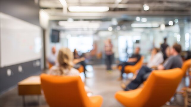 A blurred image of a modern meeting space with people seated and engaging in discussion, showcasing a collaborative environment.