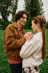 Fototapeta premium Young couple enjoys a romantic stroll through the park, sharing smiles and love in nature