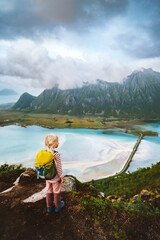 Naklejka premium Child traveling in Norway hike in Lofoten islands active family vacations outdoor healthy lifestyle 5 years old kid girl backpacker enjoying sea aerial view from Matmora mountain
