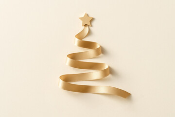 Golden ribbon forming christmas tree shape on a beige background is a festive and elegant symbol of christmas celebration, offering a modern and minimalist take on traditional holiday decor