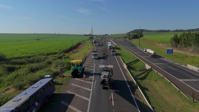 Workers Operating Machinery Applying Asphalt on Road Construction