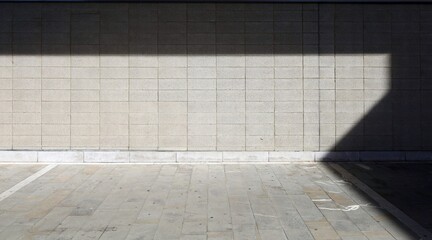 Rough concrete tile wall and dirty stone tile floor. Shadow in the upper and right side. Background...