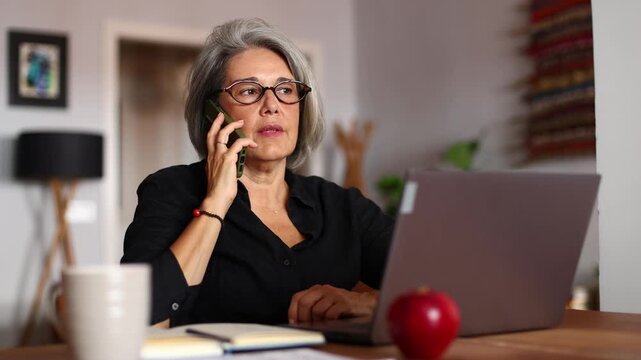 Businesswoman working from home and making a phone call