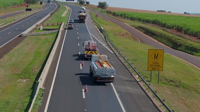 Workers Operating Machinery Applying Asphalt on Road Construction