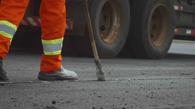 Workers Operating Machinery Applying Asphalt on Road Construction