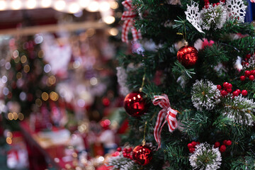 Several Christmas trees adorned with ornaments and lights brighten the evening atmosphere of a festive event shop inviting people to gather and celebrate