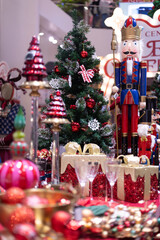 Several Christmas trees adorned with ornaments and lights brighten the evening atmosphere of a festive event shop inviting people to gather and celebrate