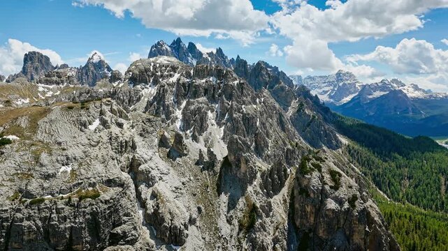 Rocky spires within Tre Cime Nature Park, aerial view. Dolomite landscape with trails and talus
