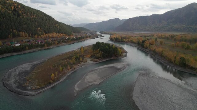 Aerial view of autumn Altai mountains, Chemall village and Katun river captured by a drone
