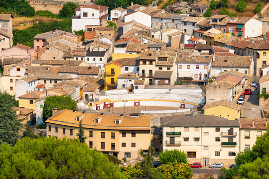 The Plaza de Toros in the village of Pastrana, Spain, surrounded by historic residential buildings on a sunny summer day
