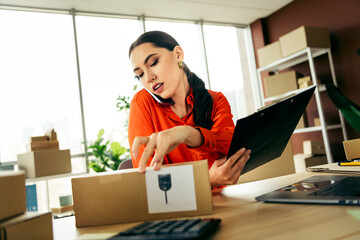 Starting a small business entrepreneur managing ecommerce orders and logistics in a modern office setting with laptop and packages