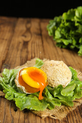 Golden Egg Yolk with Runny Center on Fresh Lettuce Leaves - Organic Breakfast Ingredient