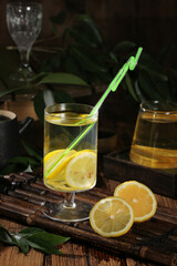 Fresh Lemonade with Lemon Slices and Green Straw on Rustic Wooden Tray - Summer Citrus Drink