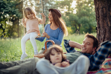 Fototapeta premium Young family having a picnic in the park