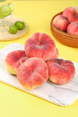 Fresh Ripe Peaches on Cutting Board with Summer Fruit Display on Yellow Background