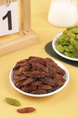 Xinjiang Raisins and Green Dried Fruits Two Color Set on Light Wooden Background