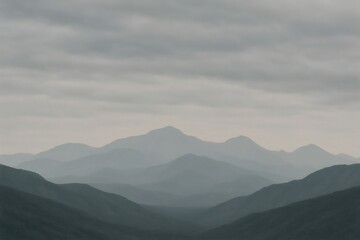 Fototapeta premium Layers of mountains fading into the distance under a cloudy sky, creating a serene and minimalist landscape