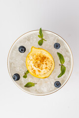 Top view of a warm lemon passet served in a white bowl with crushed ice. On a white background