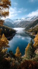 Obraz premium A tranquil autumn landscape featuring a serene lake surrounded by majestic mountains and colorful foliage under a clear blue sky.