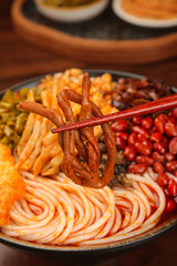 Liuzhou Snail Rice Noodles Guangxi Chinese Cuisine with Chili Oil Peanuts Seasoning Wooden Table
