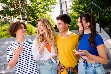 Smiling teenagers outdoors enjoying casual moments together on a sunny day during summer near concrete steps.