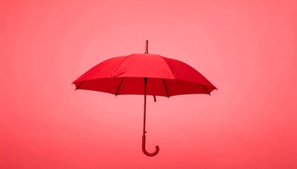 Single red umbrella suspended mid-air against solid red background—minimalist monochrome composition evokes protection, solitude, and bold artistic symbolism through color and form.